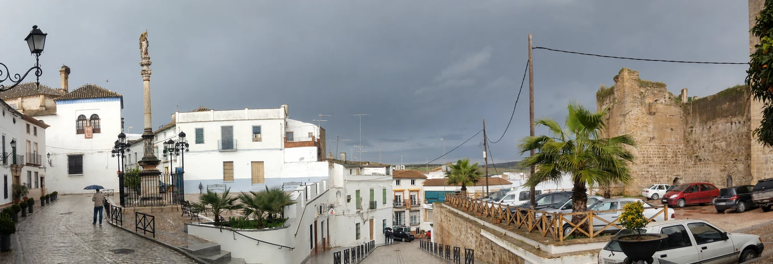 Vista panorámica del Llano de San Rafael en Castro del Río, con el monumento, las casas blancas y la muralla del castillo.