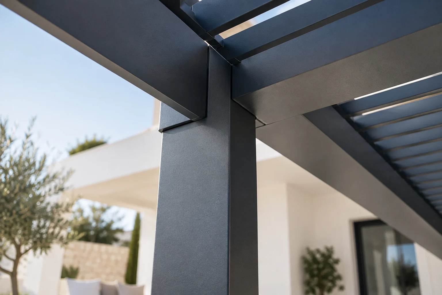 Unión entre pilar y viga de una pérgola metálica antracita.